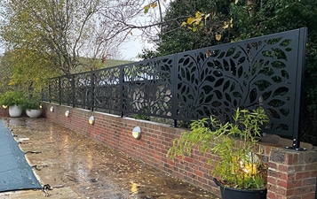 Decorative panels on top of a brick wall by a pool that is covered